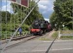 Dollertalbahn, ein kaum bekanntes Museumsjuwel.

020+020T système Mallet n° 10416 muss vor der Querung der Straße nach Masevaux anhalten, damit man sicher rüberkommt. Ein wenig gewöhnugsbedürftig ist dabei schon, dass die Lok am Straßenrand dräut, während noch die Schranken runtergelassen werden. Dieser Vorgang, mal mit Kurbeln, mal mit technischer Hilfe erscheint den Augen doch ein wenig seltsam. Burnhaupt, August 2017.