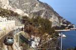 Auf ihrem Weg von Menton nach Nizza fährt BB 25623 im März 1987 mit einem Personenzug in Cap Martin ein