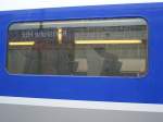 Das Bahnhofsschild des Karlsruher HBF gespiegelt im Fenster des TGV POS.