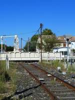 Frankreich, Languedoc, Gard, Aigues-Mortes. Die Drehbrücke über den Kanal auf der Eisenbahnlinie (Nîmes -) Saint-Césaire - Aigues-Mortes - le Grau-du-Roi. Hier ist sie um 90 Grad gedreht um die Schiffe auf dem Canal du Rhône à Sète vorbeifahren zu lassen. Fotografiert am Kreisverkehr, den die Bahn hier durchquert (siehe Karte). 13.09.2014