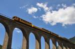 Le Petit Train Jaune am 14.08.2013 in der Mittagssonne auf dem Sjourn-Viadukt in der Nhe von Thus-entre-Valls in Sdfrankreich (Nhe Perpignan) Diese Touristenzge sind sehr beliebt und fahren
