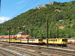 Blick von bergangsbahnsteig der Normalspurlinie aus Perpignan auf die Schmalspurlinie nach Latour-de-Carol am 30.05.2006 im Bahnhof Villefranche-de-Conflent auf das Depot des Train jaune mit den