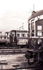 Mont-Blanc-Express__Die Ahnen. Niederbord- und Personenwagen, seit 1958 nicht mehr im Linienbetrieb, abgestellt im Bf St-Gervais-le-Fayet. Im Vordergrund das Gesicht der Nachfolgegeenration Z 604 ab 1958.__12-09-1976 