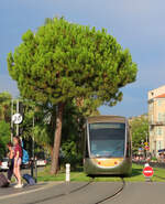Die Strassenbahn fährt an der Strassenkreuzung Fontaine du Soleil ins Grüne. Nizza, 29.08.2019
