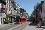 Eine Straßenbahn in Orange -     Citadis-Tram 111 in der Rue du Vesle in der Innenstadt von Reims.