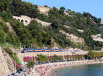 Regionalzug zwischen Nizza und Monaco fährt bei Villars sur Mer dem Badestrand entlang, der an einem Samstagnachmittag recht gut besucht ist.