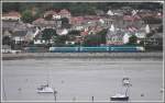 Entlang der Llandudno Bay bei Deganwy verkehren ein Triebzug Class 175 und ebenfalls ein Bus, beide betrieben von Arriva.