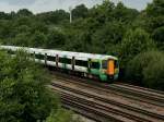 Ein moderner Triebzug  Class 377  der Electrostar-Familie hat den Flughafenbahnhof von London Gatwick verlassen und beschleunigt Richtung Sden.