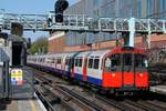 Ein Zug der Type  1973 Stock  der Picadilly Line bei der Einfahrt in die Station Barons Court.