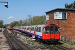 Ein vom Tw.102 geführter Zug der Picadilly Line passiert den Stellwerksturm der Haltestelle Rayners Lane. (18.04.2018)