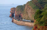 Ein Lokalzug von Paignton nach Exmouth fährt zwischen Teignmouth und Dawlish durch eine imposante Landschaft mehr oder weniger direkt dem Meer entlang. Dawlish, 17.5.2022