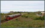 Geschoben von der D100  Elizabeth  rollt die U-Bahn-Garnitur 1044/45 der Alderney Railway am 02.05.2026 am Fort Corblets vorbei Richtung Braye Road.