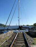 Blick vom Fussgänger-Uebergang auf der Ostseite auf die abgedrehte Clachnaharry Railway Swing Bridge, währenddem ein Schiff durch den Kanal gleitet.