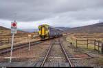 ScotRail 156 474 erreicht am 26. April 2019 auf dem Weg von Mallaig nach Glasgow Queen Street den Bahnhof Corrour.
Standort Bahnübergang (Perronzugang) über stillgelegtes Gleis.