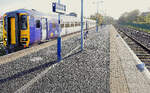 An der Lancaster - Morecambe Linie: Im grellsten Morgenlicht wartet  Northern  Zug 156 452 auf Abfahrt in Morecambe, Richtung Lancaster.