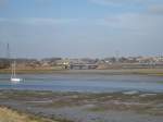 Ein Schnellzug, gefhrt von einer Class 90, von Ipswich nach London Liverpool St berquert am 21.02.09 die Brcke ber den Meeresarm bei Manningtree, Essex.