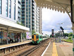 Class 377: Alt und neu, wie so oft in Grossbritannien - nostalgische Bahnhofsdächer und moderne Wohnblocks.