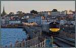 Im letzten Tageslicht rollt der Triebwagen 484002 der Island Line am 24.04.2026 �ber den Ryde Pier. Im Hintergrund ist die Station Ryde Esplanade zu sehen. Am Standort des Fotografen befindet sich die Endstation Ryde Pier, wo in die Schiffe nach Port ...