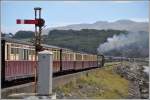 Auf dem Damm, genannt Cob, zwischen Porthmadog und dem Depot Boston Lodge passiert der 13.34 nach Blaenau Ffestiniog das Aus- und Einfahrsignal von Porthmadog.