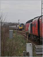 Während der Edinburgh - Aberdeen Virgin Train East Cost HST 125 Class 125 in Stonehavn auf die Abfahrt nach Aberdeen wartet, erreicht der CrossCountry Diesltriebzug 221 132 Stonehaven.