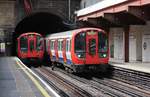 London Underground  Begegnung zweier Züge der Metropolitian-Line: Während ein Triebzug die Station Barbican verlässt, erreicht ein anderer Triebzug der gleicher Baureihe, die Station.