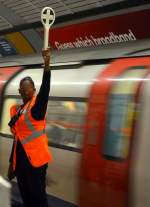 Handbetrieb(Version 2 mit Anonymisierung): Zur Unterstützung der Fahrer in der Rush Hour werden bei der Londoner Underground Hilfskräfte mit Signalkellen eingesetzt.  Swiss Cottage , 10.7.2015