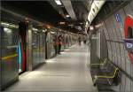 Grau ist die vorherrschende Farbe -    Blick in eine der übereinander liegenden Bahnsteigröhren der Station Westminster der Jubilee Line in London.