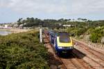 Es ist nur sehr schwer mglich, in Penzance Bahn und Meer einigermassen stimmig auf ein Bild zu bekommen: Auf beinahe der ganzen Strecke zwischen dem Bahnhof und St. Michaels Mount, wo sich die Linie Richtung St. Erth ins Landesinnere vom Ufer entfernt, strennen entweder ein engmaschiger rund zwei Meter hoher Zaun oder dichte Brombeerranken den  West Coast Foot Path  von der Great Western Main Line. 
Eine brauchbare Stelle findet sich auf einer Fussgngerbrcke, wo ich dieses Foto vom 1047GW - Service (Penzance > London Paddington) schiessen konnte.
31. August 2013