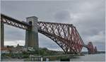 Die Forth Bridge von Nord Queensferry Nord gesehen, mit einem in Kürze in Nord Queensferry ankommenden Abellio ScotRail Dieseltriebwagen der Class 158.