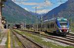 Der ALe 501 078 nach Novara verlässt am 08.05.2024 den Bahnhof Domodossola. Im Vergleich zu mitteleuropäischen Bahnen wirken die Fahrleitungsmasten des italienischen Gleichstromsystems erstaunlich zierlich. Im Hintergrund die über 3000 m hohen Berge der Leone-Gruppe, die die Grenze zur Schweiz bilden.