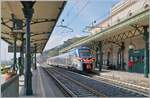 Der Zug spielt ist bei diesem Bild nur eine Nebenrolle; vielmehr zeigt das Bild zahlreiche kleine Details im prachtvollen Bahnhof von Taormina Giardini, wie z.B die Bahnhofsuhr, die Bahnsteigdachkonstruktion, die Beleuchtung oder des ehemalige Stellw ...