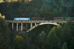 Eine EU43 der RTC überquert mit einem Güterzug, auf der Fahrt in Richtung Süden, eine Brücke nahe Fortezza/Franzensfeste.