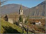 Von einer E 646 gezogen fährt der Trenord Regionalzug 20235 Richtung Milano Porta Garibaldi. Etwas älter ist die Kichte links im Bild, die Chiesa  San Quirico. Sie stammt aus dem XI Jahrhundert und somit die ältets Kirche der Region Ossola. Es wird vermutet, dass hier früher ein keltisch-etruskischert Tempel sand.
