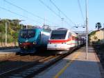 Ein Pendolino (ETR 480) berholt einen Regionalzug (E 464), der auf dem Gegengleis fhrt, im Bahnhof San Vincenzo im Juni 2005