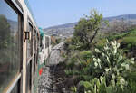Fahrt bei schönstem Wetter und mit offenen Fenstern im Dieseltriebwagen von Adrano nach Randazzo durch die spezielle Landschaft am Fuss des Ätnas in der Nähe von Bronte.
