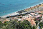 Regionalzug von Messina nach Catania fährt in den Bahnhof Taormina-Giardini ein, fotografiert von einem Aussichtspunkt im Städtchen Taormina.