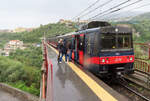 Ein Bahnhof an spezieller Lage: auf einer Brücke! Regionalzug von Sorrento nach Napoli beim Fahrgastwechsel in Seiano. Seiano, 1.5.2023