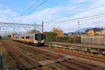 Serie 129, die neuen Triebzüge für die Präfektur Niigata (Japan, am Japanischen Meer). Ausfahrt von Zug 129-114 in Richtung des im Hintergrund sichtbaren heiligen Berges Yahiko. Yoshida, 12.November 2018 