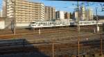 Serien 411/415 und 717 in den Abstellgleisen des Zentralbahnhofs von Kagoshima: Die (1987 aufgelöste, bankrotte) Staatsbahn baute riesige Zahlen von gleichartigen und ziemlich phantasielosen Zügen, so dass JR Kyûshû dann mit grosser Energie an die Erneuerung von Technik, Service und Design gehen musste. Doch noch heute besteht ein Teil der Lokalzüge auf der Insel Kyûshû aus alten Zweistromzügen Serie 411/415 (Gleichstrom/Wechselstrom; Vierwagenzüge; Steuerwagen Serie 411 + 2 Motorwagen Serie 415 in der Mitte) und den 6 Wechselstrom-Zweiwagenzügen Serie 717 mit nur zwei statt drei Seiteneingängen. Links Zug mit Steuerwagen KUHA 411-331, recht versteckt sich der im Design ähnliche Zug 717-204. 31.Juli 2013. 