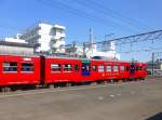 Serie 713: Der strahlend rote motorisierte Endwagen des Zweiwagenzugs 713-2 in Minami Miyazaki, 3.August 2013.