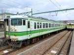 Serie 115 der Region Niigata: Fast der gesamte Regionalverkehr in dem mit Gleichstrom elektrifizierten Netz der Präfektur Niigata in Nordwest-Japan am Japanischen Meer wird (allerdings nur noch für kurze Zeit) mit Zügen Serie 115 erbracht. Dafür gibt es dort 14 Vierwagen-, 33 Dreiwagen- und 19 Zweiwagenzüge, wovon ein Schulungszug. Von den 1963-1983 gebauten Zügen für Steilstrecken und kalte Gebiete (total 1921 Fahrzeuge) existiert noch etwa die Hälfte. Die Grundfarbe der Züge der Präfektur Niigata ist weiss mit grünem Band, wie im Bild der Steuerwagen KUHA 115-553. Rechts ein Zug der Yahiko-Linie. Yoshida, 17.Oktober 2011. 