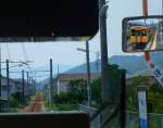 Serie 105 im Hinterland von Fukuyama: Ein Bild der Strecke aufzunehmen ist durch das verglaste Führerstandrückfenster und die verschiedenen Anzeigetafeln im Frontfenster hindurch schwierig. Hier steht Steuerwagen KUHA 104-26 des Zuges KUMOHA 105-31 am Zwischenhalt in Tode. 13.August 2013. 