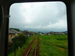 Matsuura-Bahn, Imari-Arita-Linie: Unterwegs durch tiefgründe Reisfelder in Wagen 616 unmittelbar vor der Haltestelle Midaibashi, 7.August 2013.
