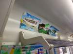 Matsuura-Bahn - Die Fahrgäste: Fast alle Drittsektorbahnen kooperieren eng mit den lokalen Schulen und Kindergärten und lassen die Kinder Bilder der Bahn malen, um ihre Bindung an die Bahn zu stärken. Diese Bilder werden dann in den Wagen aufgehängt, wie hier in Wagen 605. 26.Juli 2013. 