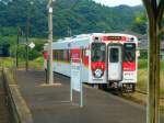 Matsuura-Bahn: Kreuzung mit Wagen 617 an der Haltestelle Emukae Shikamachi, 26.Juli 2013. Die Wagen wirken zwar schön neu, doch in der extremen Luftfeuchtigkeit rostet alles schnell.  