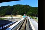 Die Sanriku-Bahn: Vor dem Tsunami stand die lustige Station Shimanokoshi mitten auf der Brücke. Nach der Katastrophe war die Brücke eingestürzt und die Station nur noch ein Trümmerhaufen. Jetzt wurde sie wieder aufgebaut, aber nicht mehr mitten auf der Brücke, sondern am Brückenende. Gut sichtbar die noch lange nicht beendeten Wiederaufbauarbeiten da, wo einst ein Dorf stand. Aufnahme aus Triebwagen 706, 27.September 2014.  