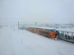 Tsugaru-Bahn: Ein Zug mit den zwei Triebwagen 102 und 101 und zwei Touristenwagen im Schneesturm in Goshogawara.