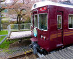 Hankyû-Konzern, Arashiyama Linie: Triebwagen 7017 wartet in Arashiyama auf den Stossverkehr mit Tausenden von Touristen, die einen friedlichen Tag am Fluss und inmitten der Kirschblüten verbracht haben. Wie man sieht, ist ein Grossteil der Kirschblüten allerdings schon am Boden. 8.April 2015.