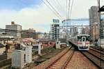 Sanyô-Konzern, Expresszüge: Seit 1998 fahren Expresszüge von Himeji aus die ganze 92,5 km lange Strecke bis in die Stadt Ôsaka hinein, 32,1 km davon über die Gleise des Hanshin-Konzerns. Im Bild hat Zug 5022 (Endwagen 5611) sein Ziel in der Metropole fast erreicht. Hanshin Noda, 7.Oktober 2016. Detail: Die Stationsdurchfahrten werden vom Bahnsteigbeamten überwacht; man sieht den Schaffner zuhinterst im Zug den Gruss des Bahnsteigbeamten erwidern. 
