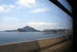 Iyo-Bahn, auf der Takahama-Linie in Zug 714-764. Typische Strecke beim Hafen Takahama an der Inlandsee, dem Teil des Pazifischen Ozeans, der sich zwischen Shikoku und der japanischen Hauptinsel Honshû schiebt und für seine Tausenden von kleinen und kleinsten Inseln berühmt ist. Hier kommen die Fährschiffe von der Stadt Hiroshima an. 8. April 2008. 